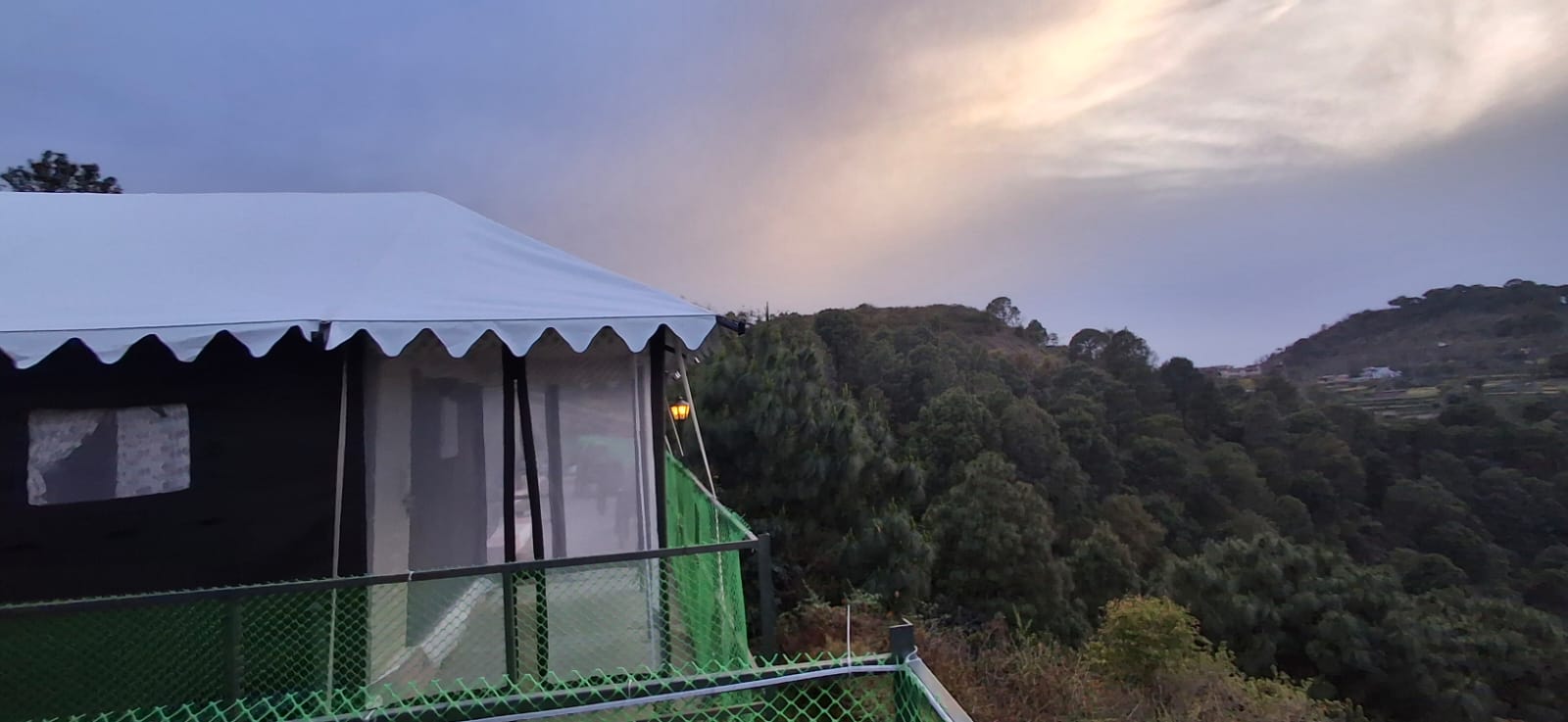 Hilltop Swiss tent with dramatic Morni Hills valley and stormy sky